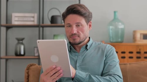 Adult Man Using Tablet Device Indoors
