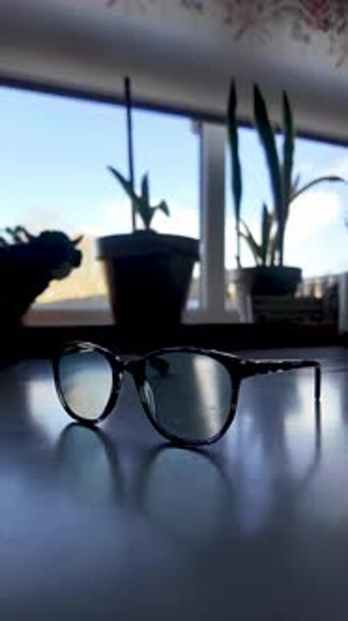 Vision correction and eye health with a close up of reading glasses on a kitchen countertop.