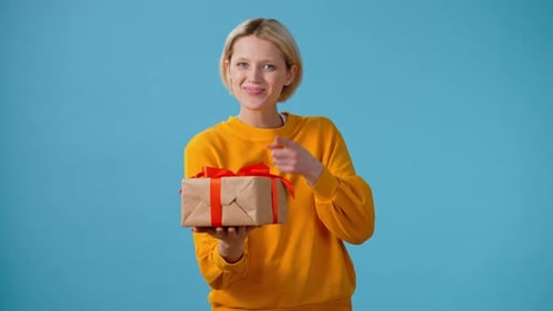 Happy Woman Presents Wrapped Gift With Red Ribbon