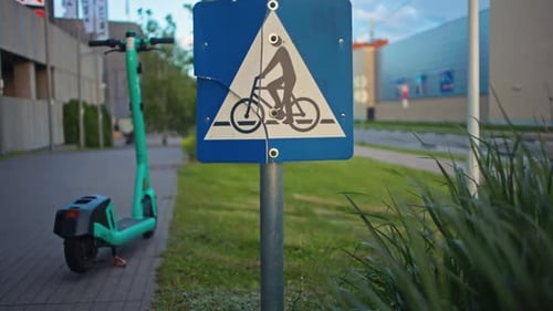 A Bicycle Lane Sign is Prominently Displayed Alongside an Electric Scooter Parked on the Bustling