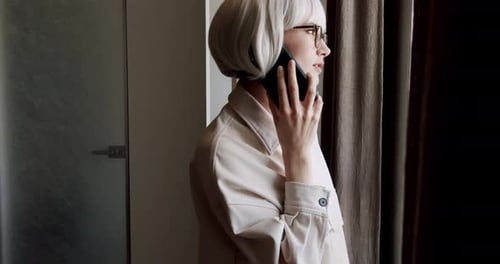 Woman With Bobbed Hair Talking on Phone Indoors