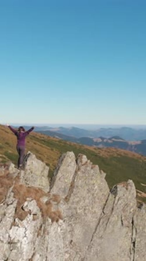 The Triumphant Hiker Reaches the Rocky Summit Absorbing the Majestic Mountain View with a Sense of