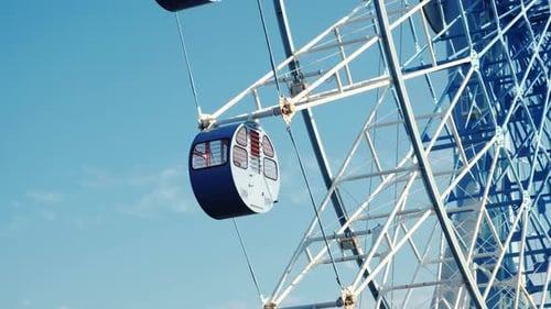 Spinning Ferris Wheel Against a Blue Sky