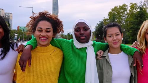 Vista frontal de mulheres jovens e diversas se abraçando caminhando juntas ao ar livre