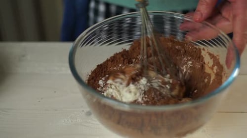 Baking ingredients being mixed in clear bowl