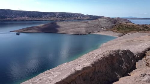 Drone fly through rocky mountains, revealing the coast.