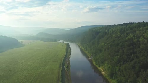 Fluss schlängelt sich anmutig durch eine leuchtend grüne Wiese