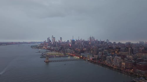 Lower Manhattan Skyline with Cloudy Sky at Dusk Featuring the Hudson River and Urban Landscape From