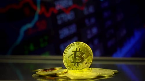 Pile of Bitcoins With Moving Stock Market Graph Background