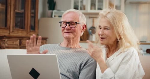 Senior Couple Video Calling on Laptop at Home