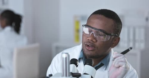 Scientist Working with Microscope in Modern Laboratory
