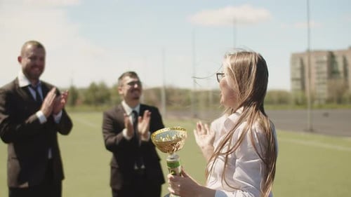 Young Caucasian Woman Celebrates Recieving an Award for Achievement of High Work Results