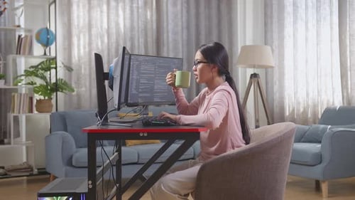 Asiatische Programmiererin im Teenageralter trinkt Wasser, während sie eine App entwickelt