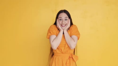 Me siento bien. Mujer vestida de amarillo de pie en el estudio y mostrando emociones