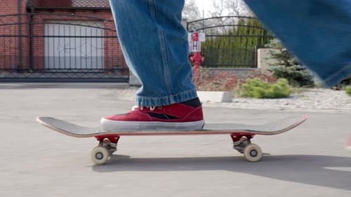 Person riding skateboard on street in residential neighborhood
