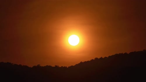 Sonnenuntergang über einem Berg im orangefarbenen Himmel