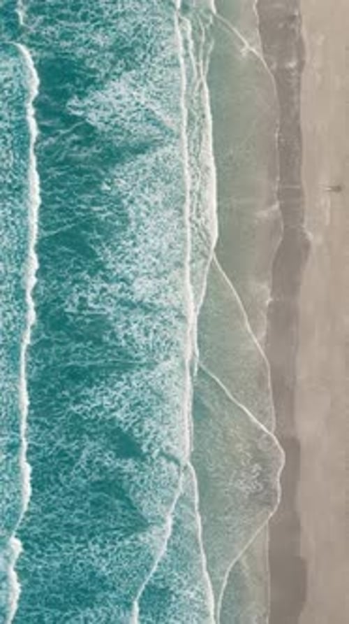 Vertical video of Drone aerial view of paradise beach. Turquoise sea water and clear sand at sunset.