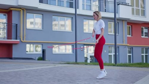 Woman Jumps Rope for Fitness in Urban Setting