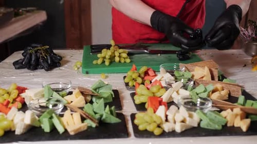 Chef Adding Grapes on Food Platter at Table