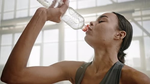 Fit Woman Hydrates in Gym After Workout