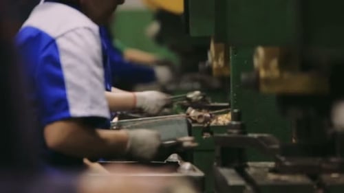 Die Leute arbeiten in einer Fabrik. Manuelle Montage von Teilen im Unternehmen