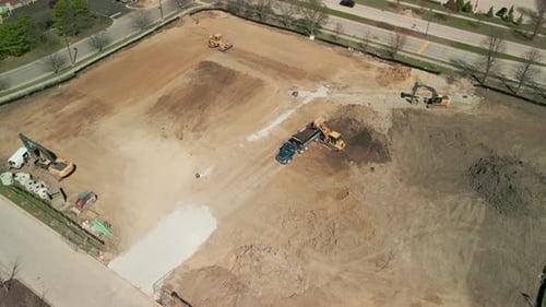 Imágenes panorámicas de un Zumbido Una excavadora nivela un terreno para un desarrollo de construcción Wide Shot