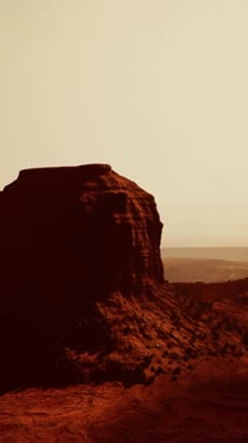 Aerial View of a Massive Rock Formation Standing Proudly in the Desert