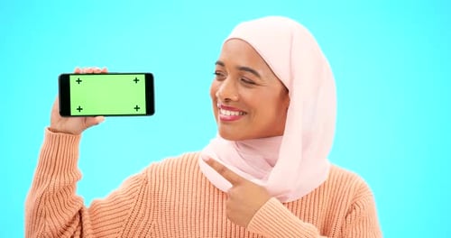 Islam, phone or green screen and a woman on a blue background in studio holding a display