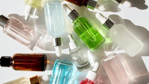 Colorful Dropper Bottles on White Surface with Shadows