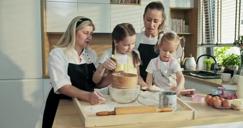 Moderne Familie in der Küche versucht Mehl in Glasschale zu sieben