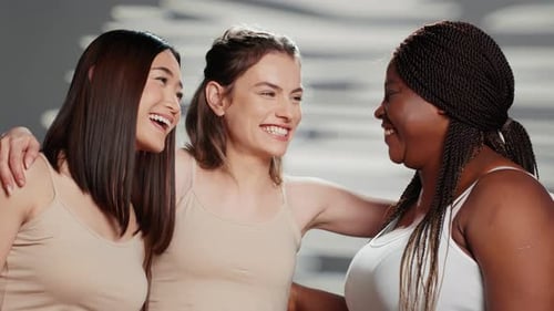 Three Smiling Women Friends Embracing in Studio