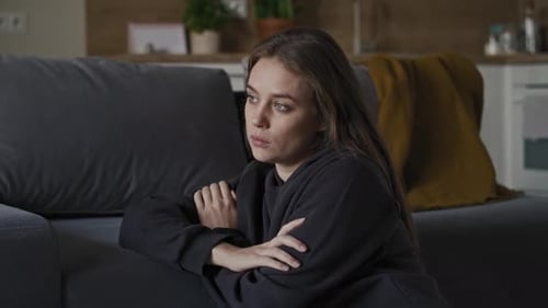 Thoughtful Woman Sitting on Floor at Home