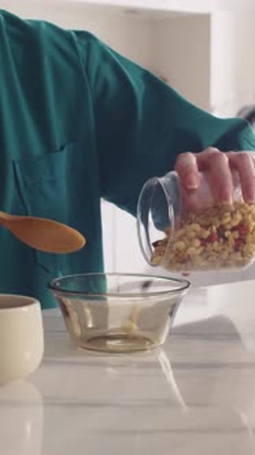 Granola and Milk Poured into Bowl for Breakfast