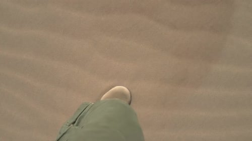 Walking Across Arid Sand Dunes in Desert Landscape