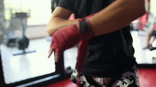 Boxer Wraps Hands with Red Athletic Tape