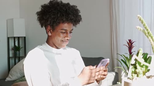 Young Adult Using Smartphone Indoors During Daytime
