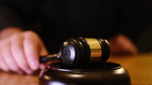 El mazo de un juez ocupa un lugar destacado en un tribunal y simboliza la autoridad y el orden.