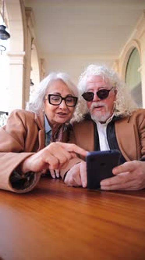 Happy Senior Couple Using Mobile Phone Together