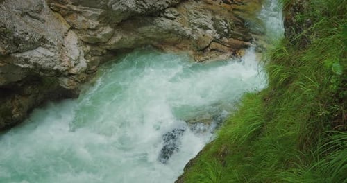 Rapid clear fresh water of mountain river flows among the rocks in rocky gorge. Fast flowing stream