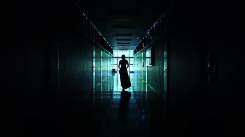 Silhouette Walking Down Dark Hospital or Prison Hallway