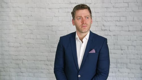 Serious Man in Suit Looks Around Thoughtfully