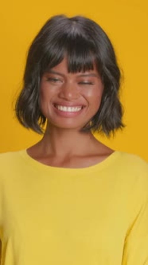 Woman Smiling in Yellow on Solid Background