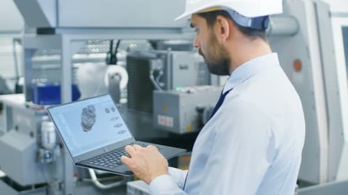 Engineer Working on a Laptop, He's Designing New Efficient Engine in CAD Program. Out of the Office