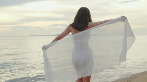 Woman Wear Bikini Swimsuit with Blowing Sarong Enjoying Walking and Spin Body at Beach