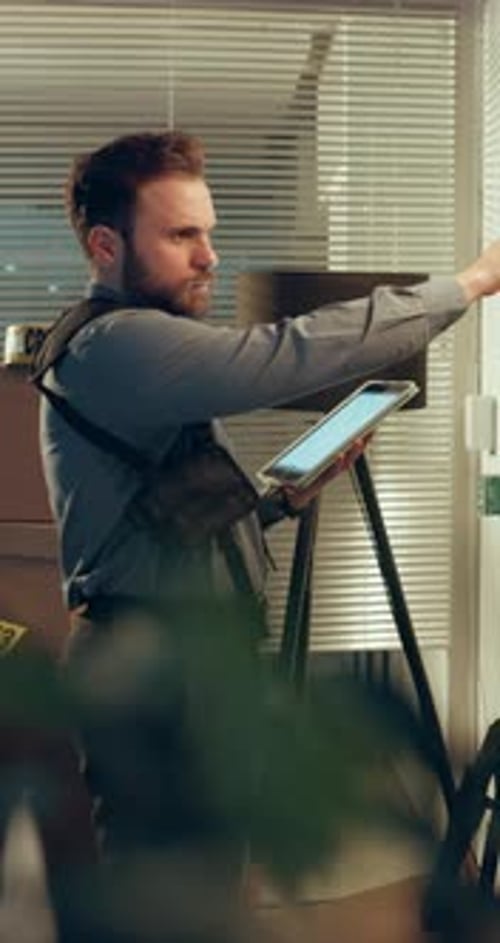 Investigation, night or man at station with tablet, cross reference or information on evidence