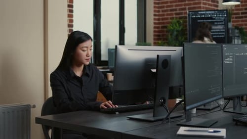 Asiatischer Programmierer entwickelt Software am Computertisch