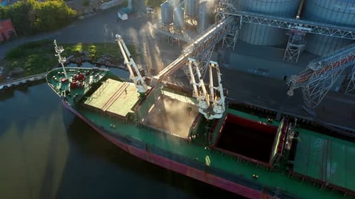 Aerial of Wheat Loading to Bulker Ship Cargo Hold at Sea Grain Elevator in Sea Port Wheat Shipment