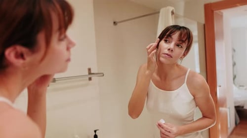 Woman Styling Eye Area in Bathroom