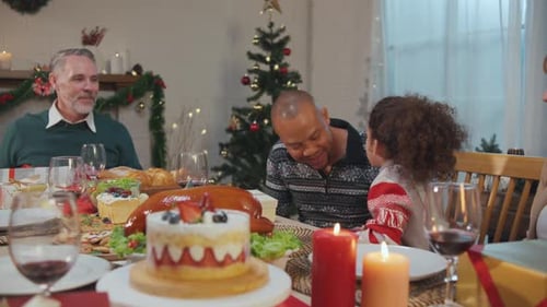 Family Celebrates Christmas With Kiss at Festive Table