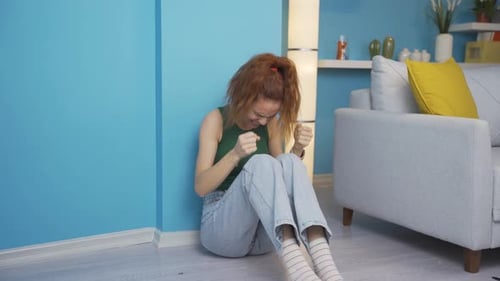 Young Woman Crying on the Floor in Home